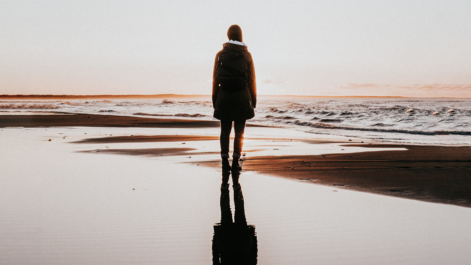 Fotografía de mujer reflejada en la playa